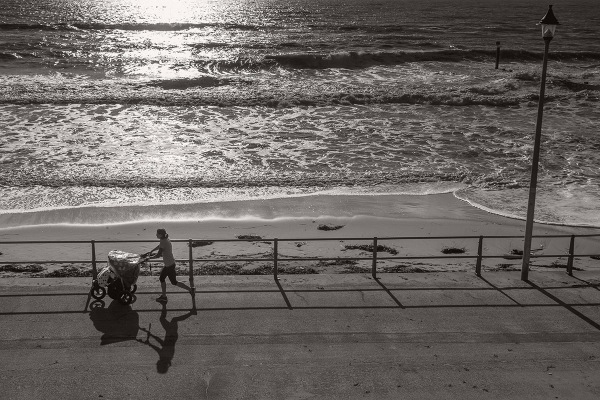 ©Neil Turner, November 2014. A young woman jogs along the promenade near Portman Ravine in Bournemouth with a child in a pushchair.