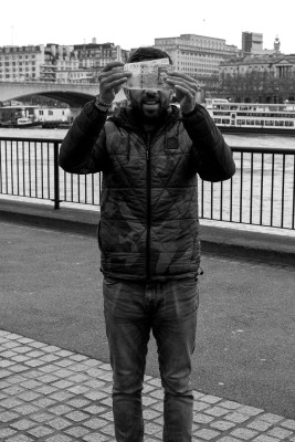 Shell game players hides his face with £50 notes on the South Bank in London. © Neil Turner, December 2015